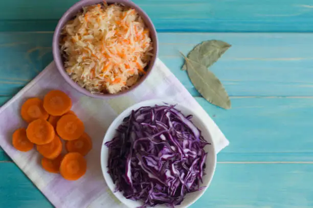 Photo of Photo of cabbage and carrot salad and salad of purple cabbage on a bright blue background.