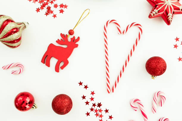 istock Christmas composition. Red toys, candy canes and confetti on white background. Flat lay, top view. 1075563322