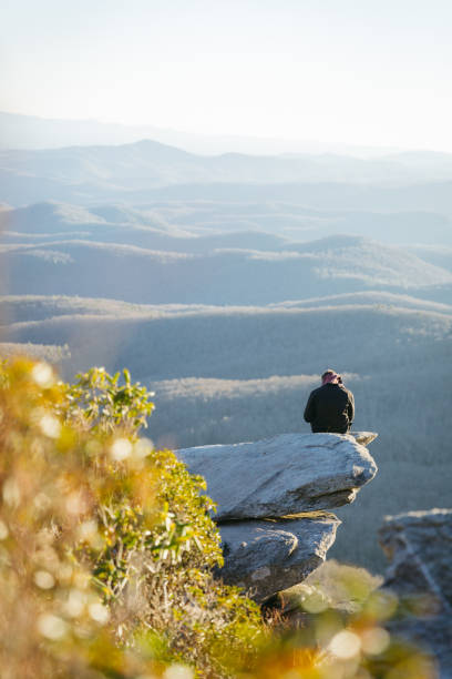 istock Man using phone sitting on a rock on the Blue Ridge Parkway 1075566450