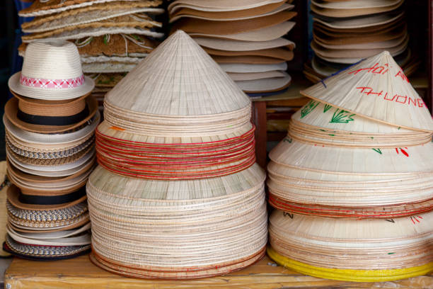 Straw hats for sale on the stalls of a shophouse in Hoi An, Vietnam.