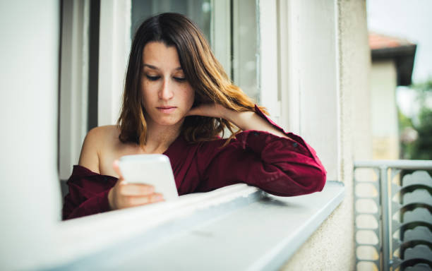 istock Girl in red shirt texting 1075576318