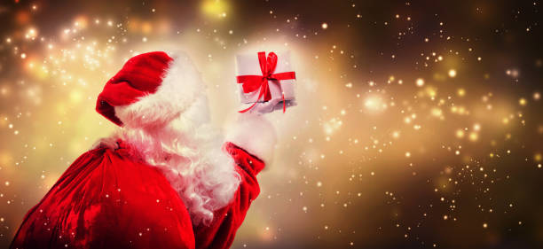 istock Santa holding a Christmas gift 1075583938
