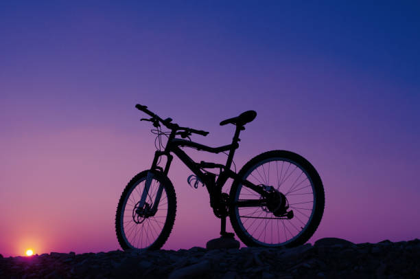 istock Silhouette of mountain bicycle against sunset. Toned image 1075586000