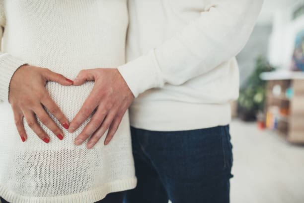 istock Parents hands touching pregnant belly 1075589638
