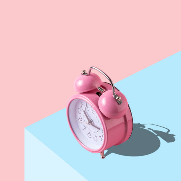 istock Pink alarm clock on bright background. Minimal art concept. 1075592628