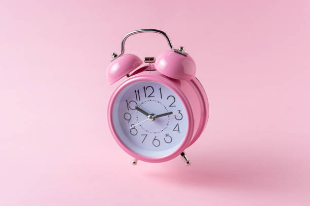 istock Pink alarm clock on pastel pink background. Minimal concept. 1075592844