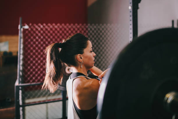 istock Athletic young woman doing some weightlifting exercises 1075593302