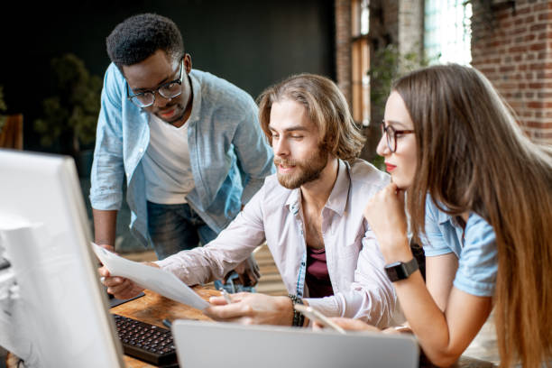 istock Young coworkers working with computer indoors 1075597260