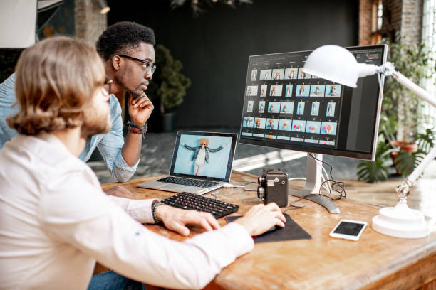 Two photographers working on the computers in the studio