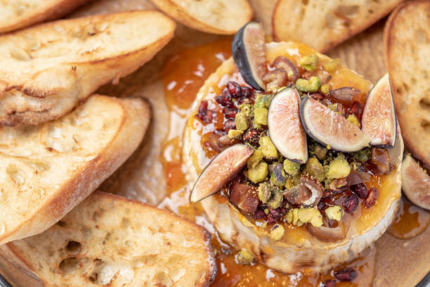 istock Cheese (could be goat cheese, brie or camembert) with pistachos, figs and honey 1075604940