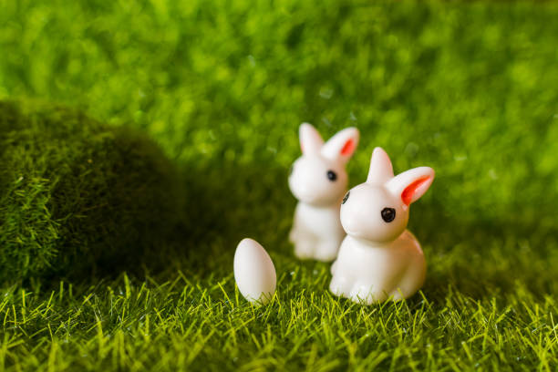 istock two figures of a rabbit and an egg on the grass. happy Easter concept 1075608676