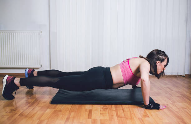 istock Girl doing pushups in gym 1075608984