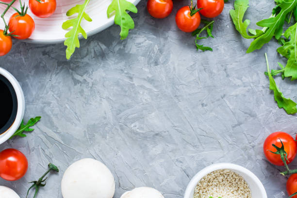 istock Food ingredients lined frame on a concrete background: cherry tomatoes, mushrooms, arugula, sesame and balsamic sauce 1075609626