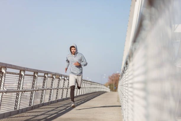 istock Sporty young man running on a bridge. 1075613086