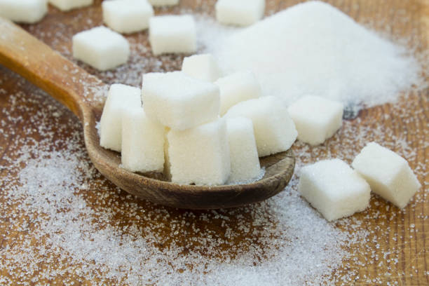 istock White sugar in wood spoon on wooden table. 1075625138