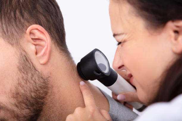 istock Doctor Checking Skin On Man's Neck 1075627396