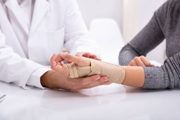 Doctor Checking Fractured Hand Of A Woman Close-up Of Doctor's Hand Checking Fractured Hand Of A Woman orthopedist stock pictures, royalty-free photos & images