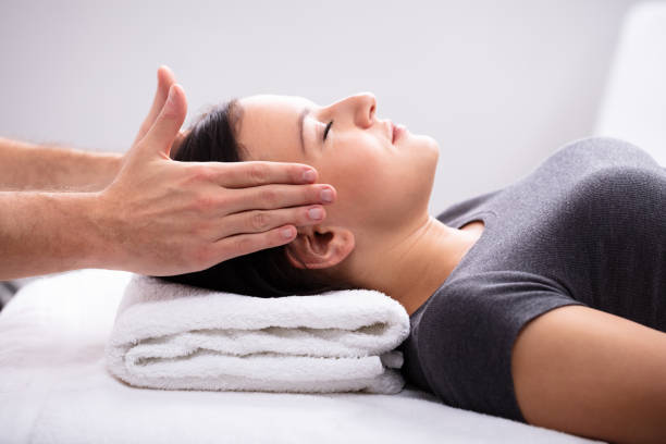 therapist giving reiki healing treatment to woman - reiki alternative therapy massaging women imagens e fotografias de stock