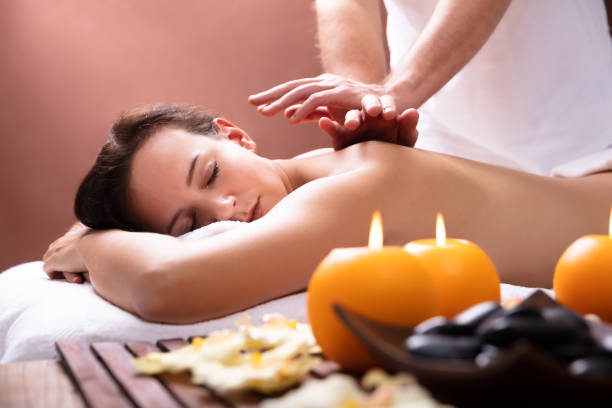 Therapist Giving Back Massage To Young Woman Therapist's Hand Giving Back Massage To Relaxed Young Woman In Spa shiatsu stock pictures, royalty-free photos & images