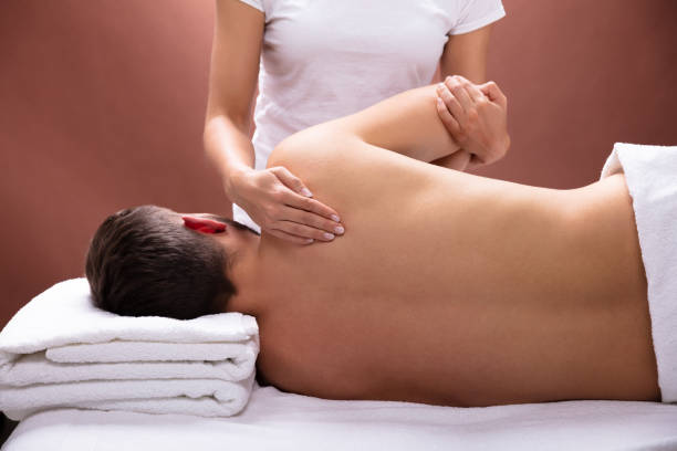 thérapeute donnant des épaules massage pour homme - physical therapy back table patient photos et images de collection