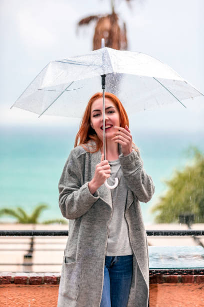 istock Woman under the rain with umbrella 1075629326