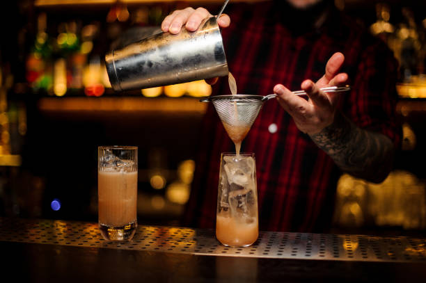 istock Barman pouring fresh lemonade cocktail into a glass 1075633856