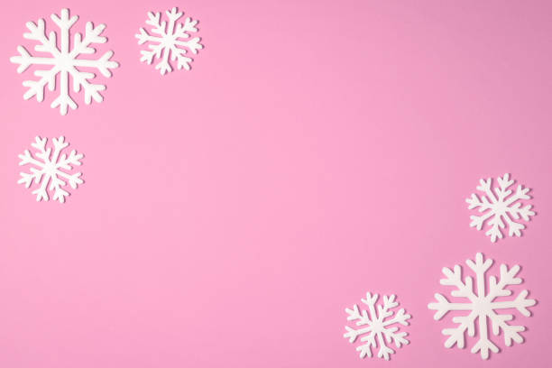istock Christmas snowflake border frame on pink background. Christmas minimal texture with copy space. top view 1075634732