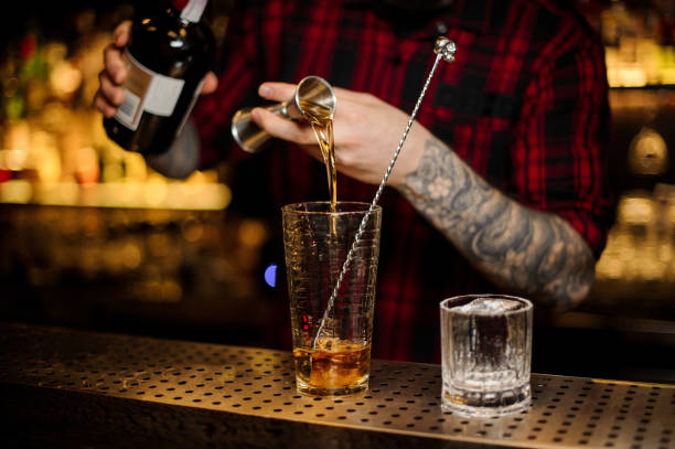 istock Barman hand pouring strong alcohol into a cocktail glass 1075643114