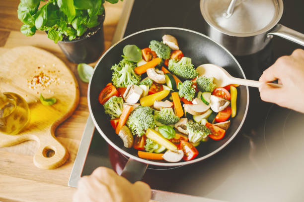 istock Man cooking fresh vegetables in pan 1075657808