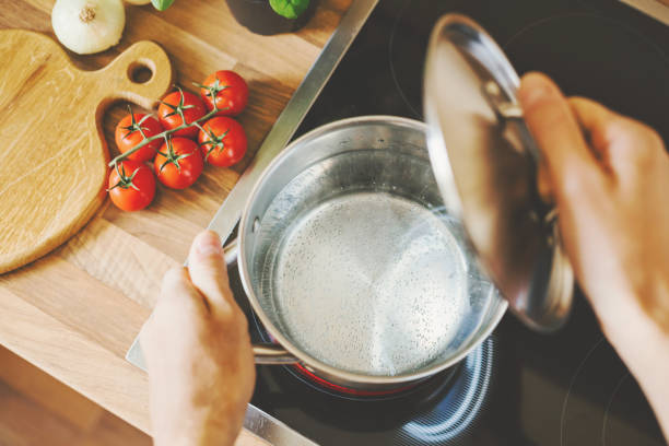 Man checking boiling water in cooking pot. stock photo