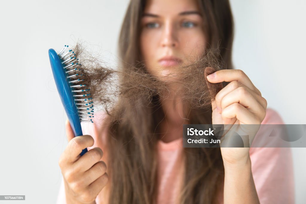Young woman is upset because of hair loss Young woman is very upset because of hair loss Women Stock Photo