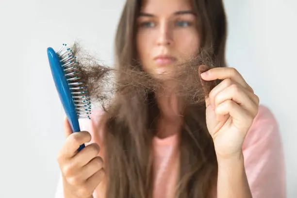 Young woman is very upset because of hair loss