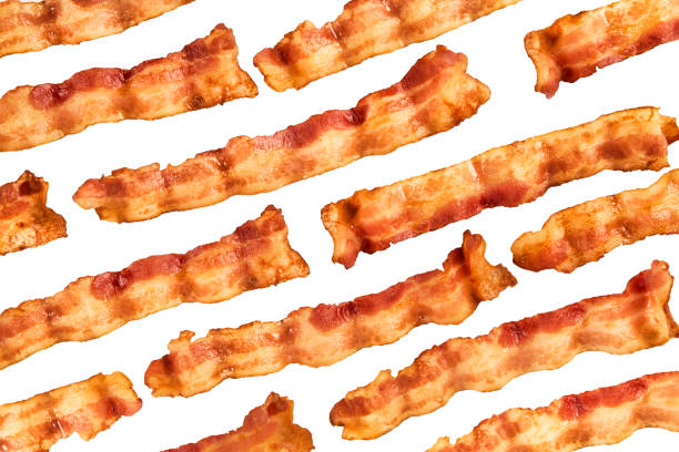 Background of bacon slices disposed in diagonal and isolated on white Background of bacon slices disposed in diagonal and isolated on white background. Directly above. cooked bacon slice stock pictures, royalty-free photos & images