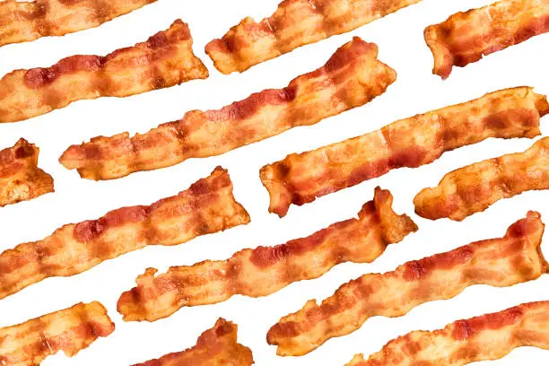 Photo of Background of bacon slices disposed in diagonal and isolated on white