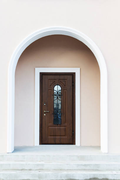暗い家の木製玄関のドア。ライトグレー日中自宅で素朴な正面玄関のビュー。垂直方向のショット。 - door facade house front view ストックフォトと画像