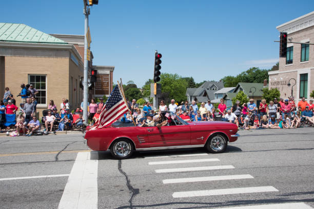 Ford Mustang with Veterans Naperville, Illinois, United States-May 29,2017: Bright red Ford Mustang convertible with veterans during the Memorial Day parade with spectators in Naperville, Illinois ford crossing stock pictures, royalty-free photos & images