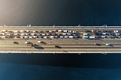 Aerial view of road bridge across river with heavy traffic jam in one direction. Rush hour with mash and overloading of road infrastructure. Resolving of car traffic jam