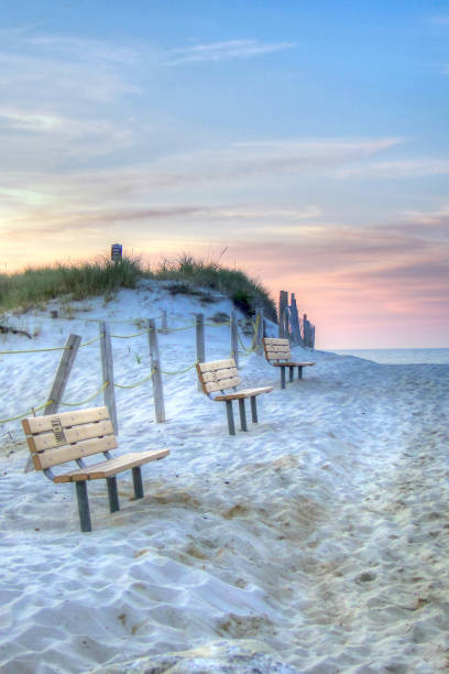 benches line the dunes at mayflower beach - beach bench cape cod sunset imagens e fotografias de stock