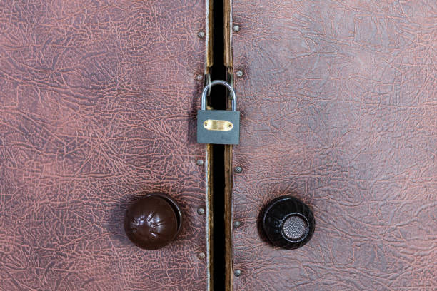 istock Locked padlock on old vintage door with round plastic door handle 1075715170