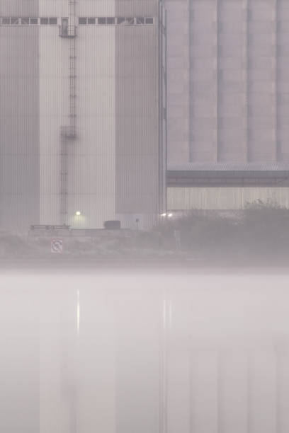 Industrial building near a foggy canal stock photo