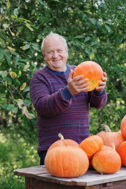 istock elderly men with pumpinks outdoor 1075733460