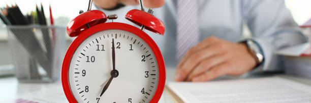 istock Male hand on the alarm clock a red 1075734148
