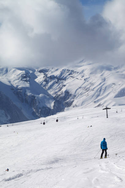 istock Skier descend on snowy ski slope 1075738176
