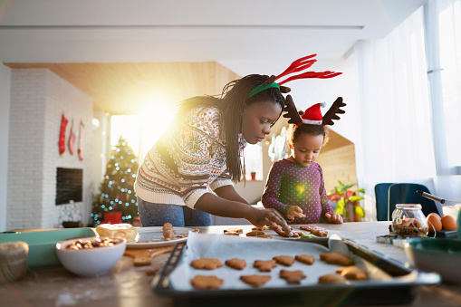 Mother making Christmas cookies with her daughter.