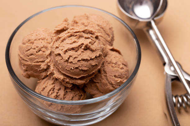 istock Chocolate Ice Cream in a Glass Bowl on a Brown Background 1075750086