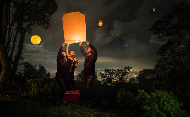famille volante lanterne loy krathong festival - ballooning festival photos et images de collection