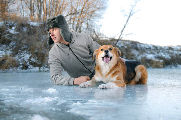 istock guy lies on the ice with the dog 1075760588