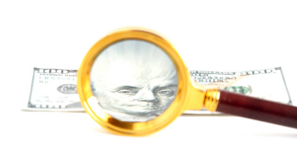 istock Examining the American Dollar Close Up with a Magnifying Glass 1075773374