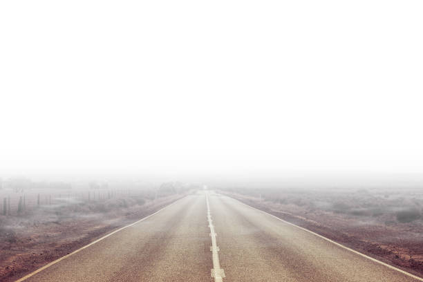 istock Rural highway passing through countryside and disappearing in white mist 1075780814