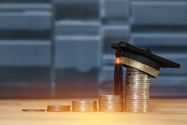 istock Education Graduate study scholaship concept : Congratulations graduates on top stacks of coins on wood table gray background. Ideas Educational for successs study or business have to use many Money 1075790198